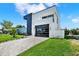 Modern home with a black and white color scheme, garage, and a well-manicured lawn at 908 W Fribley St, Tampa, FL 33603