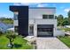 Modern home showcasing clean lines, a dark garage door, and manicured landscaping at 908 W Fribley St, Tampa, FL 33603