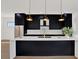Elegant kitchen with black cabinets, white countertops, stainless steel appliances, and pendant lighting over the island at 908 W Fribley St, Tampa, FL 33603
