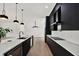 Modern kitchen with black cabinets, white countertops, an island with a sink, and stainless steel appliances at 908 W Fribley St, Tampa, FL 33603