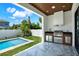 Features an outdoor kitchen with built-in grill and prep area next to the pool at 908 W Fribley St, Tampa, FL 33603