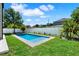 Backyard view with a rectangular pool surrounded by green lawn and white fencing at 908 W Fribley St, Tampa, FL 33603