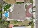 Aerial view of a home with a brick driveway, landscaping, and backyard featuring a unique swimming pool at 931 Gulf Blvd, Belleair Beach, FL 33786
