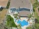 Aerial view showcasing a backyard with a uniquely shaped pool, lounge chairs, and well-manicured landscaping at 931 Gulf Blvd, Belleair Beach, FL 33786