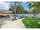 Serene backyard with lush green grass, a paved patio, and comfortable seating for outdoor relaxation at 931 Gulf Blvd, Belleair Beach, FL 33786
