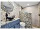 Chic bathroom with custom vanity, stone shower, pebble floor, and contemporary fixtures at 931 Gulf Blvd, Belleair Beach, FL 33786