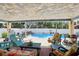 Spacious covered patio with stylish seating, overlooking the refreshing pool and lush backyard at 931 Gulf Blvd, Belleair Beach, FL 33786