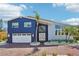 Charming two-story home with a brick driveway, well-manicured landscaping, and a white two car garage at 931 Gulf Blvd, Belleair Beach, FL 33786