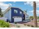 Beautiful two-story home featuring a brick driveway and garage, enhanced by lush greenery and swaying palm trees at 931 Gulf Blvd, Belleair Beach, FL 33786