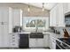 Well-lit kitchen features white cabinets, a farmhouse sink, and views to the exterior at 931 Gulf Blvd, Belleair Beach, FL 33786