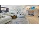 Bright living room features a stone fireplace, modern furniture, light wood flooring, and access to the outdoor patio at 931 Gulf Blvd, Belleair Beach, FL 33786