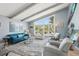 Comfortable living room with a vaulted ceiling, blue sofa, area rug, and picturesque views at 931 Gulf Blvd, Belleair Beach, FL 33786