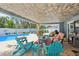 Inviting covered patio featuring comfortable seating and views of the pool and landscaped backyard at 931 Gulf Blvd, Belleair Beach, FL 33786