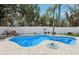 Inviting pool with a uniquely shaped design, surrounded by lush landscaping and a privacy fence at 931 Gulf Blvd, Belleair Beach, FL 33786