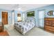 Cozy bedroom featuring a brass bed frame, floral bedding, wood dresser, and soft, natural lighting at 9674 104Th Ave, Largo, FL 33773