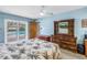 Bright bedroom with blue walls, ceiling fan, dresser, and sliding glass doors to the pool area at 9674 104Th Ave, Largo, FL 33773