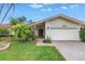 Charming home exterior with a red tile roof, two-car garage, and lush landscaping at 9674 104Th Ave, Largo, FL 33773