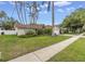 Charming home featuring a well-manicured lawn, mature trees, and an American flag at 9674 104Th Ave, Largo, FL 33773