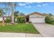 Charming single-story home with a well-manicured lawn, mature trees, and brick driveway at 9674 104Th Ave, Largo, FL 33773