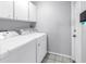 Functional laundry room with white washer and dryer, overhead cabinets, and tile flooring at 9674 104Th Ave, Largo, FL 33773