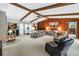 Cozy living room with exposed beams, neutral carpet, and a decorative wood accent wall at 9674 104Th Ave, Largo, FL 33773