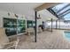Covered patio area featuring brick pavers, seating, and views of the screened-in pool at 9674 104Th Ave, Largo, FL 33773