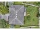 An aerial view of a home with a large roof, backyard, and surrounding landscape in the community at 10833 Breaking Rocks Dr, Tampa, FL 33647