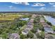 Expansive aerial view of homes along a lake, showcasing a vibrant community and lush green surroundings under a partly cloudy sky at 10833 Breaking Rocks Dr, Tampa, FL 33647