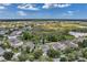 Aerial view of a residential neighborhood with well-maintained homes and green spaces under a bright, partly cloudy sky at 10833 Breaking Rocks Dr, Tampa, FL 33647