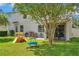 Large backyard featuring playset, grill, patio, and screened-in porch at 10833 Breaking Rocks Dr, Tampa, FL 33647