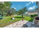 Green backyard featuring a playset, patio area with outdoor seating, and manicured landscaping at 10833 Breaking Rocks Dr, Tampa, FL 33647