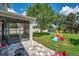 Backyard view showing a screened patio, stone patio, playset, and lush landscaping at 10833 Breaking Rocks Dr, Tampa, FL 33647