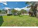 Expansive backyard featuring lush lawn, mature trees, and ample space for recreation at 10833 Breaking Rocks Dr, Tampa, FL 33647