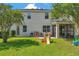Spacious backyard features a well-maintained lawn, patio, and screened-in porch at 10833 Breaking Rocks Dr, Tampa, FL 33647