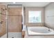 Elegant bathroom featuring a separate shower and a luxurious soaking tub with tile surround at 10833 Breaking Rocks Dr, Tampa, FL 33647