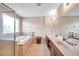 Bright bathroom with a soaking tub, glass-enclosed shower, dual sink vanity, and natural light at 10833 Breaking Rocks Dr, Tampa, FL 33647