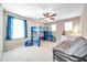 Bright bedroom featuring a blue bunk bed, cozy seating, and a ceiling fan at 10833 Breaking Rocks Dr, Tampa, FL 33647