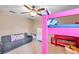 Bedroom showcasing a pink bunk bed, gray sofa, and ceiling fan at 10833 Breaking Rocks Dr, Tampa, FL 33647