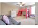 Bedroom with pink bunk bed, white dresser, and comfortable gray sofa at 10833 Breaking Rocks Dr, Tampa, FL 33647