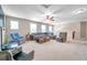 Spacious upper living room with plush carpeting, large windows, and comfortable seating at 10833 Breaking Rocks Dr, Tampa, FL 33647