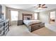 Primary bedroom suite featuring a ceiling fan and windows with decorative headboard at 10833 Breaking Rocks Dr, Tampa, FL 33647