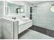 Modern bathroom featuring double vanity, a sleek glass shower and gray tile at 1178 Sultana St, Port Charlotte, FL 33952