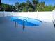 In-ground pool with metal ladders and a white concrete deck surrounded by a white fence at 1178 Sultana St, Port Charlotte, FL 33952