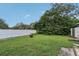 Expansive backyard with a lush lawn, mature trees, privacy fence, and a cozy fire pit area at 1206 E Frierson Ave # B, Tampa, FL 33603