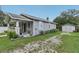 Quaint single-story home with a front porch, a well-maintained lawn, and a detached garage at 1206 E Frierson Ave # B, Tampa, FL 33603