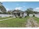 Cozy single-story home with a well-maintained lawn, a white picket fence, and a detached garage at 1206 E Frierson Ave # B, Tampa, FL 33603