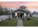 Charming single-story home with a cozy front porch and well-maintained lawn at sunset at 1206 E Frierson Ave # B, Tampa, FL 33603