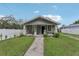 Charming single-story home with a cozy front porch, green lawn, and white picket fence at 1206 E Frierson Ave # B, Tampa, FL 33603
