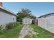 Detached garage with double doors and a gravel driveway, set against a lush green lawn at 1206 E Frierson Ave # B, Tampa, FL 33603
