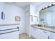 Bathroom featuring marble counters, a large mirror, and a built-in towel rack, with a neutral color palette at 1210 Wolford Dr, Trinity, FL 34655